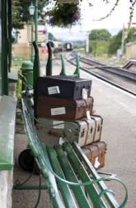 train platform with old fashioned luggage and bench