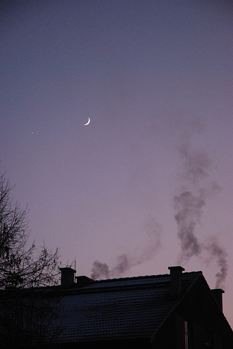 chimney smoke curling into the night air